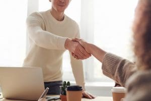 Man shaking woman's hand